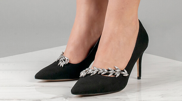 a pair of black stilletos with a silver gem garland over the front